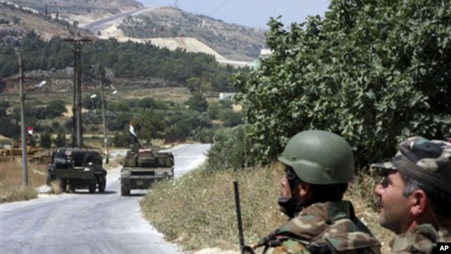 n this photo taken during a government-organized tour for the media, Syrian soldiers and armored vehicles arrive in Istabraq village near the northern town of Jisr al-Shughour, Syria, Saturday, June 11, 2011.