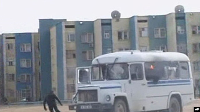 A protester runs from a police vehicle in the Kazakh town of Zhanaozen in this still image taken from video acquired by Reuters TV, December 16, 2011.