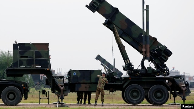 Dutch soldiers are seen standing next to a Patriot missile battery at a military base in Adana, southern Turkey, January 26, 2013.