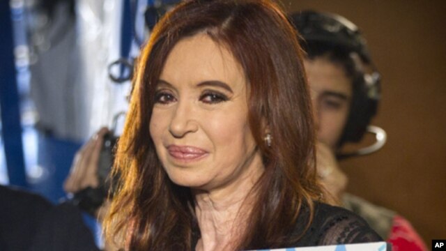 Argentina's President Cristina Fernandez holds a photo of her late husband and former Argentine President Nestor Kirchner at the Plaza de Mayo square after general elections in Buenos Aires, Argentina, Sunday, Oct. 23, 2011.