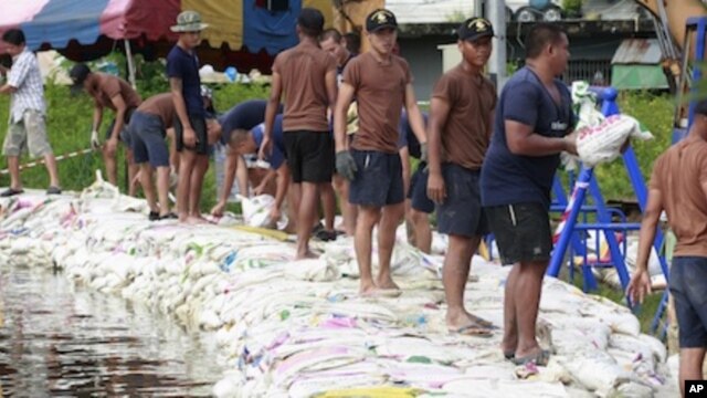 Thai soldiers pile up sand bags to make flooding barriers in Pathum Thani province, central Thailand Friday, Oct. 14, 2011.