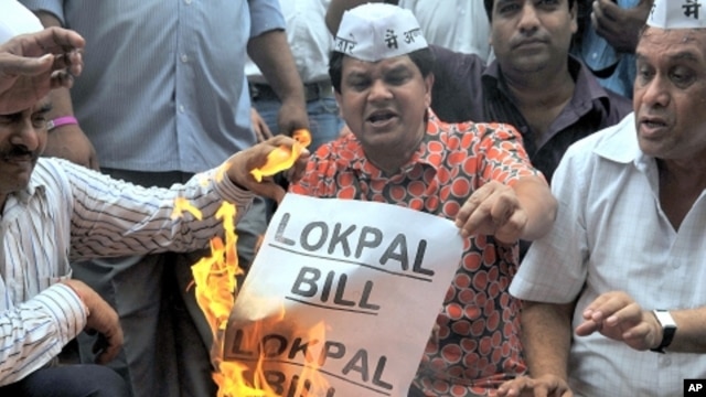 Anti-corruption activists burn symbolic copies of the Lokpal Bill (anti-corruption bill) during a protest to denounce the proposal in its current form in Mumbai on August 4, 2011.