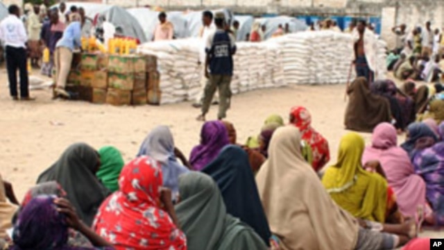 Internally displaced Somali women queue to receive food-aid rations at a distribution center, in an IDP camp in the Somali capital Mogadishu, July 26, 2011