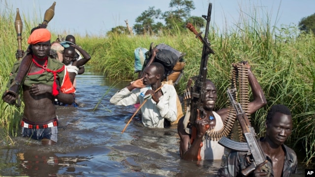 FILE - Rebel soldiers are seen protecting civilians from the Nuer ethnic group near Bentiu, South Sudan, Sept. 20, 2014. The arrival in Juba of South Sudan rebel leader Riek Machar’s forces is a crucial part to the implementation of the agreement signed last August.