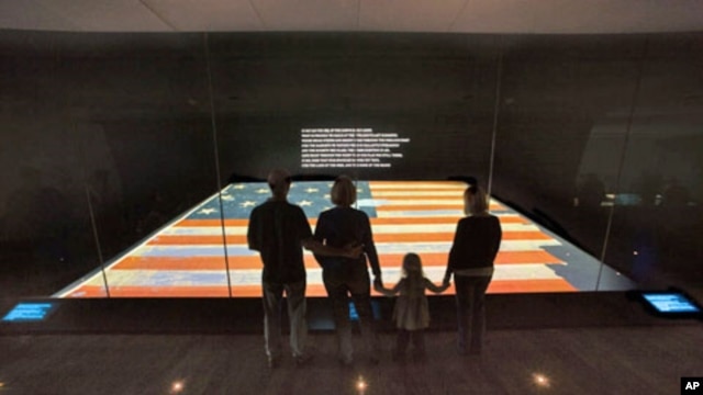 Visitors view the Star-Spangled Banner at the National Museum of American History.