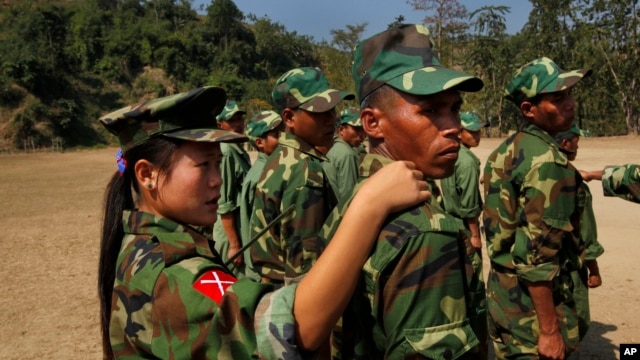 In this photo taken on Monday, Feb. 13, 2012, recruits of the Kachin Independence Army, one of the country's largest armed ethnic groups, receive training from a female instructor, left,  at a military camp near Laiza.