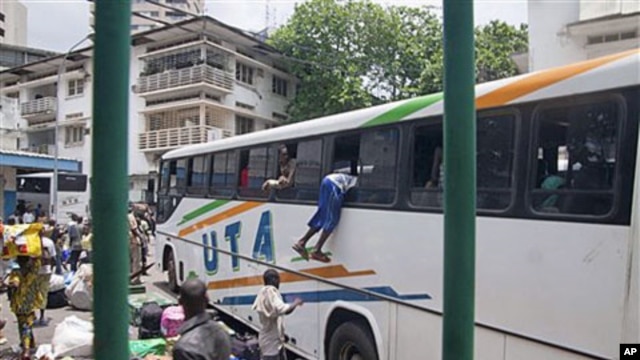 With possessions balanced on their heads, about 1,000 people frantically crowded around buses rented by Mali to evacuate its citizens from Abidjan, Ivory Coast, including a Malian man climbing into the window of a bus, March 25, 2011