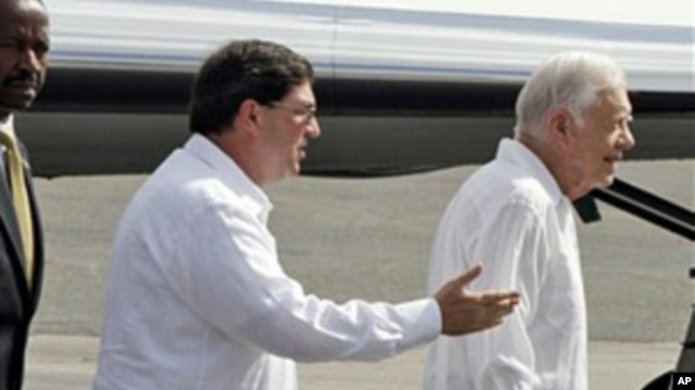 Followed by Cuba's Foreign Minister Bruno Rodriguez, former President Jimmy Carter (r) arrives to the Jose Marti airport in Havana, March 28, 2011