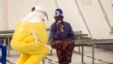 A health worker in protective gear addresses a suspected Ebola patient in a quarantine zone at a Red Cross facility in the eastern Sierra Leone town of Koidu. 