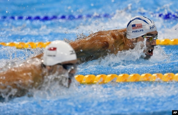 United States' Michael Phelps, top, and Singapore's Joseph Schooling compete during a men's 100-meter butterfly heat during the swimming competitions at the 2016 Summer Olympics, Aug. 11, 2016, in Rio de Janeiro, Brazil.