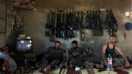 Free Syrian Army fighters sit in a house on the outskirts of Aleppo June 12, 2012. 