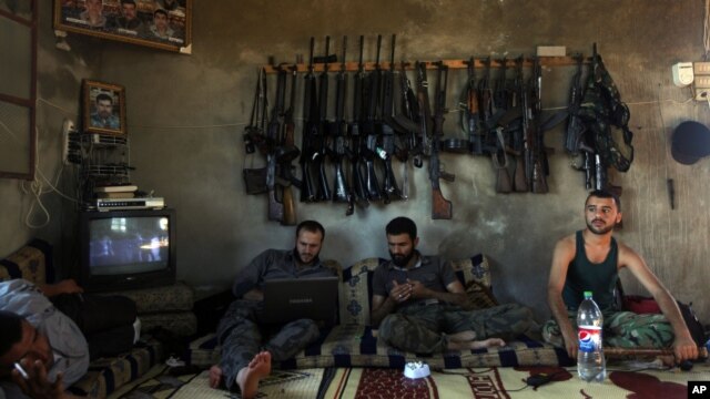 Free Syrian Army fighters sit in a house on the outskirts of Aleppo June 12, 2012. 