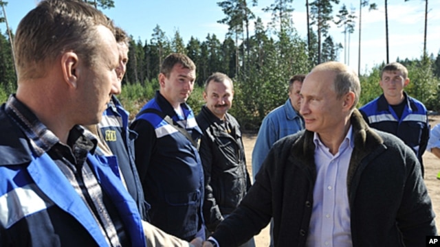 Russian Prime Minister Vladimir Putin, right, meets with employees of the Portovaya gas compressor station outside Vyborg, some 170 km northwest from St. Petersburg, Russia, Sept. 6, 2011.