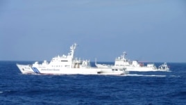 Chinese marine surveillance ship Haijian No. 51 (R) cruises next to a Japan Coast Guard patrol ship, Akaishi, in the East China Sea near the disputed isles known as Senkaku isles in Japan and Diaoyu islands in China, Feb. 4, 2013.