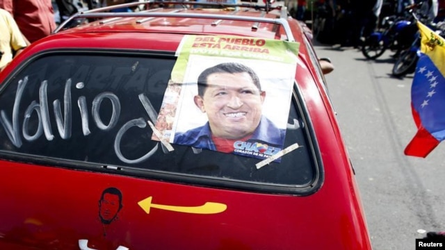 Pendukung Presiden Hugo Chavez di Caracas memasang foto Chavez di mobilnya dengan tulisan: 'Dia Telah Kembali', Senin (18/2).  