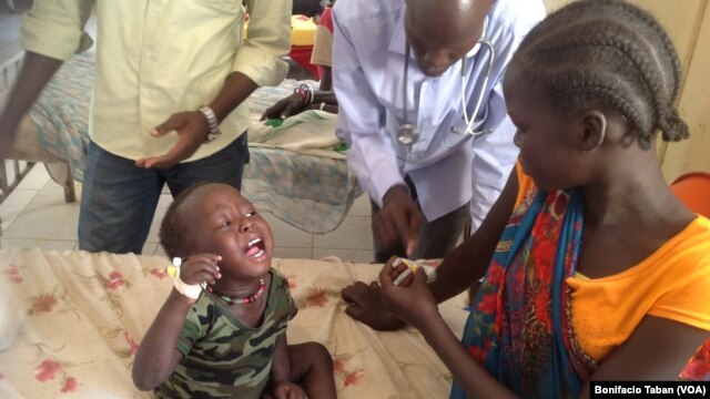 Dr. James Peter consults with Nyayub Kuol, who has brought her two-year-old son to Bentiu hospital for treatment for malaria. Unity state has seen a spike in the number of cases of malaria and Kala Azar, also called visceral leishmaniasis, especially among children. (VOA/Bonifacio Taban) 
