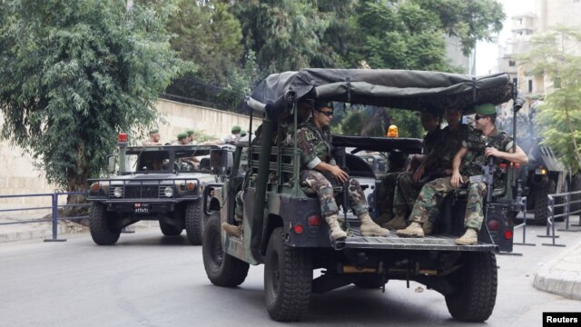 Lebanese Army soldiers sit in their military vehicles as they are deployed to secure the area near the French embassy in Beirut, September 21, 2012.