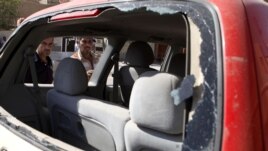 Iraqis inspect the scene of a car bomb attack in Baghdad, Sunday, Sept. 30, 2012.