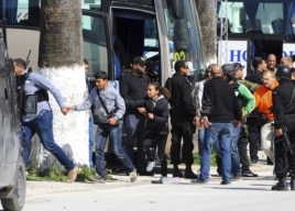 Du khách và trẻ em chạy khỏi hiện trường dưới sự bảo vệ của lực lượng an ninh võ trang Tunisia.