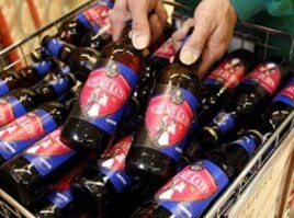 A worker poses with bottles of "Kiss Me Kate" ale at a Morrisons supermarket in Leicester.