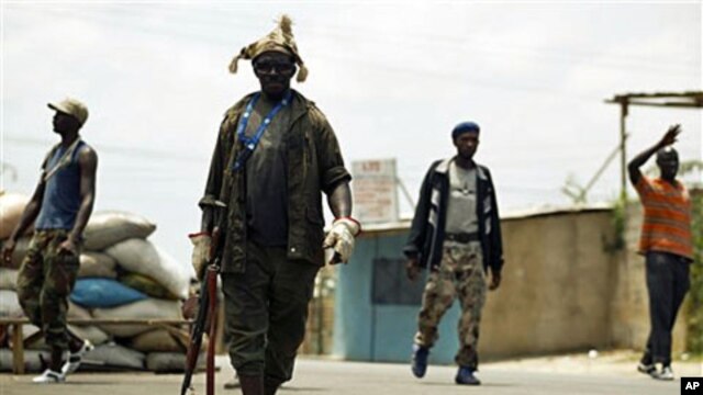 Fighters opposed to Laurent Gbagbo's bid to cling to power man a roadblock in the Abobo district of Abidjan, Ivory Coast Saturday, Mar12 2011