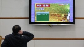 Un hombre lee sobre la alerta de tsunami tras un fuerte terremoto en el norte de Japón. La alerta fue levantada horas después.