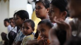 Rakhine families stay at a monastery used as a temporary shelter for people displaced by days of violence in Sittwe, capital of the western state of Rakhine, Burma, June 14, 2012.
