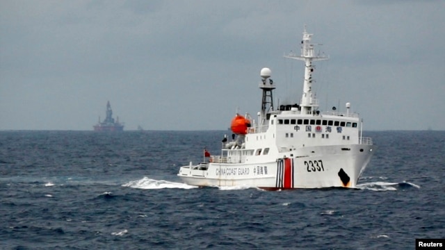 FILE - A Chinese Coast Guard vessel, with a disputed oil rig in the background, is seen in the South China Sea  June 13, 2014.