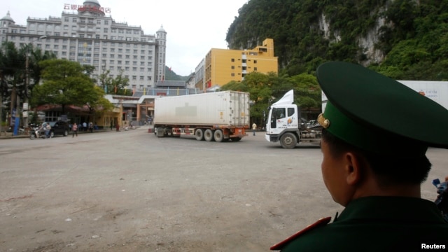 Nhân viên hải quan Việt Nam giám sát xe tải băng qua cửa khẩu Tân Thanh với Trung Quốc ở tỉnh Lạng Sơn, ngày 30/7/2014.