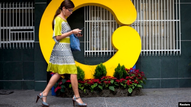 Una empleada de Globovisión camina frente a al edificio principal de la televisora, censurada por el gobierno por octava vez en ocho años.
