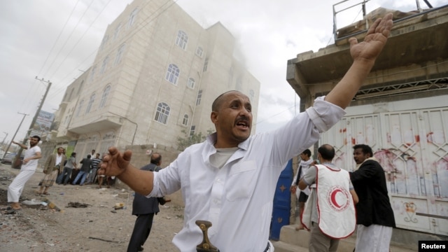 People react at the site of a Saudi-led coalition airstrike in Sana'a, Yemen, April 8, 2015.