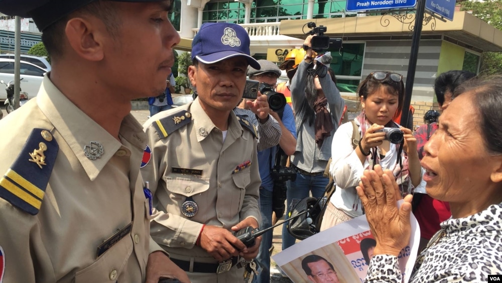 អ្នកស្រី​ សំ សំណាង​ លើក​ដៃ​សំពះ​មន្ត្រី​ប៉ូលីស​ សុំ​ឲ្យ​អ្នកស្រី​និង​អ្នក​តវ៉ា​ឯទៀត​បាន​ទៅ​ជួប​ផ្ទាល់​ជាមួយ​លោក​នាយករដ្ឋមន្ត្រី​ ហ៊ុន​ សែន​ ដើម្បី​សុំ​ឲ្យ​មាន​ការ​ដោះលែង​សកម្មជន​បរិស្ថាន​ទាំង​បី​នាក់។​ (ហ៊ុល រស្មី/VOA)