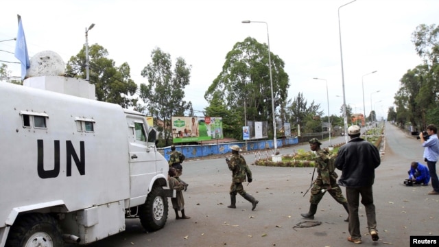 Congolese Revolution Army (CRA) rebels walk past a United Nations patrol truck parked along a street in Goma in the eastern Democratic Republic of Congo (DRC), November 20, 2012.