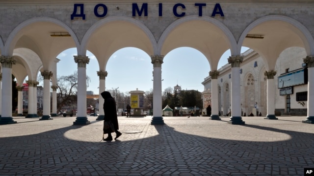 An elderly woman walks at the main railway station in Simferopol, Ukraine, Friday, March 14, 2014