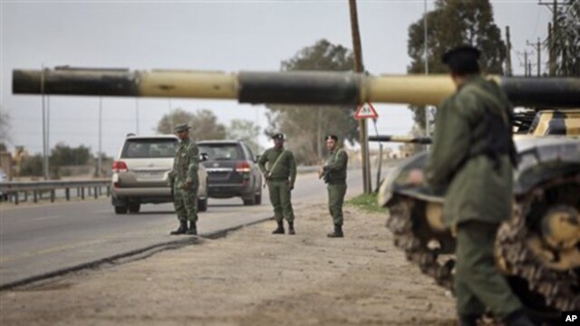Soldiers and dozens of tanks from the Libyan military's elite Khamis Brigade, led by Gadhafi's youngest son Khamis Gadhafi, take positions and check vehicles after arriving hours earlier on the road in Harshan, 10km east of Zawiya, in Libya,  Feb. 28, 201
