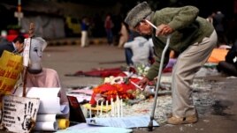 Wani dattijo a Indiya yana kunna kyandir a wurin tunawa da dalibar da ta mutu bayan an yi mata fyade a New Delhi, a kasar Indiya