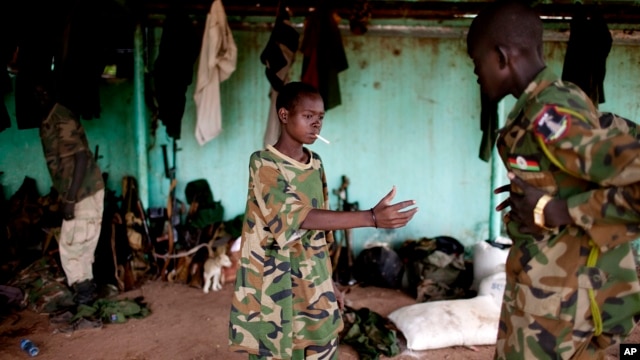 FILE - A May 2012 photo shows a young South Sudanese soldier who appeared to be drunk reaching for a lighter for his cigarette at the Sudan People's Liberation Army (SPLA) headquarters in Bentiu, Unity State.