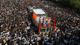 Supports of the Shiv Sena party crowd around the vehicle carrying the body of right-wing Hindu nationalist politician Bal Thackeray during his funeral procession in Mumbai, November 18, 2012. 