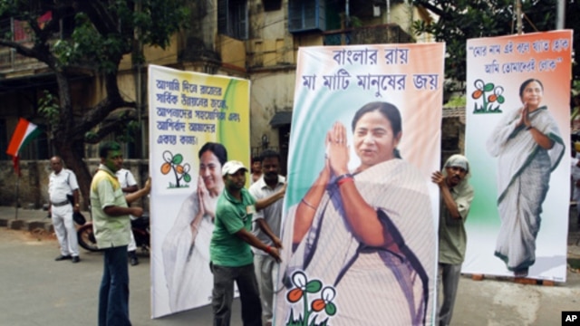 Supporters of the Trinamool Congress party, an ally to India's the ruling Congress Party, hold election billboards featuring portraits of party leader Mamata Banerjee in Kolkata, India, May 13, 2011.