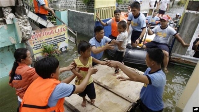Rescuers move children to an evacuation center at Malabon city, north of Manila, Philippines, Aug. 1, 2012.