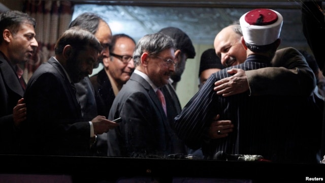 Babar Khan Ghori (R) of the Pakistan's political party Muttahida Qaumi Movement (MQM) hugs cleric and leader of Minhaj-ul-Quran Muhammad Tahirul Qadri after they reached an agreement on the fourth day of protests in Islamabad, January 17, 2013. 