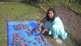 A briquette producer trained by Legacy Foundation instructors displays her wares (Photo: Legacy Foundation)