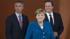 German Chancellor Angela Merkel, center, British PM David Cameron, right, and Norway's PM Jens Stoltenberg, left, arrive for a panel discussion in Berlin, Germany, June 7, 2012.