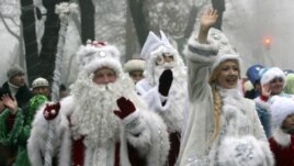 People dressed as Father Frost, the named used locally for Santa Claus, and Snow Maiden greet passers-by during a New Year parade in Bishkek, Kyrgyzstan. (Reuters Image)
