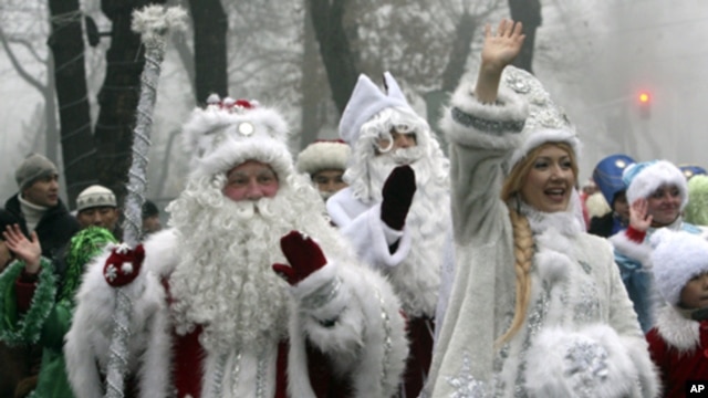 People dressed as Father Frost, the named used locally for Santa Claus, and Snow Maiden greet passers-by during a New Year parade in Bishkek, Kyrgyzstan. (Reuters Image)