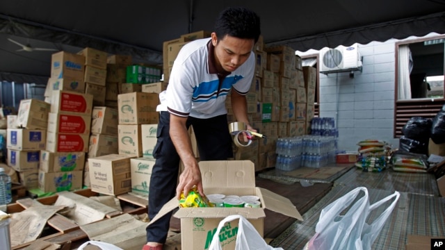 Tình nguyện viên đóng hộp mì ăn liền để gởi cho các nạn nhân lũ lụt.