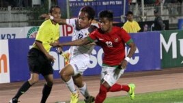 ေနလင္းထြန္းနဲ႔ အင္ဒိုနီးရွားအသင္းက Manahati L Lestusen (ယာ) တို႔အႀကိတ္အနယ္ယွဥ္ၿပိဳင္စဥ္။ (ဒီဇင္ဘာ ၁၆၊ ၂၀၁၃)