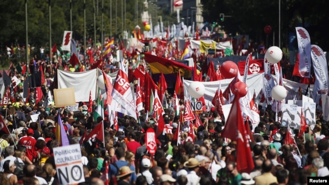 Demonstrators carry banners as they march to Madrid's Colon Square during a protest against government's cost-cutting measures, September 15, 2012.