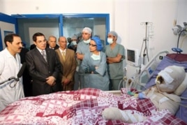 In this photo released 28 Dec 2010 by the Tunisian President's office, Tunisia's President Zine El Abidine Ben Ali, 2nd left, visits Mohamed Bouazizi, a young man who set himself on fire after police confiscated fruit and vegetables he sold without a perm