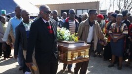 'Yan makoki suke dauke da akwatin gawar daya daga cikin ma'aikata 34 da 'Yansanda suka kashe